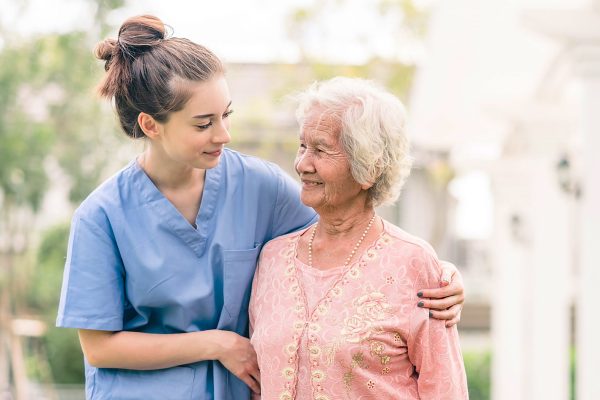 caregiver with Asian elderly woman outdoor Smiling nurse caregiver with Asian elderly woman outdoor in the park